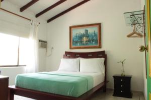 a bedroom with a bed and a picture on the wall at Timeless Oasis Hostel in Cali +47 photos