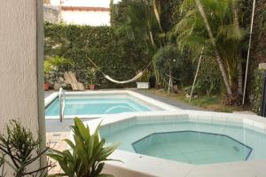a swimming pool in a yard next to a house at Timeless Oasis Hostel in Cali