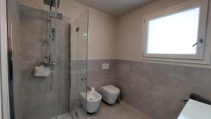 a bathroom with a shower and a toilet and a sink at Appartamento La Bussola in Còvolo +15 photos
