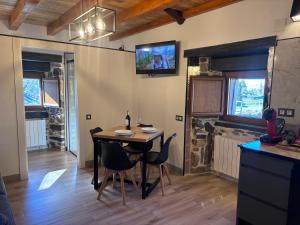 una sala da pranzo con un tavolo e una TV a parete di 27A01 Casa Uría - Cam. Santiago a Berducedo