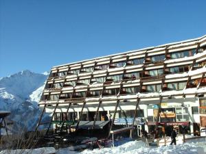 un grand bâtiment au sommet d'une montagne enneigée dans l'établissement Résidence Les Arolles - Apartement 2 pièces 6 personnes à Arc 1600 en centre station et proche des pistes MAE-1701, à Arc 1600 9 autres photos