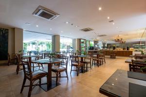 a restaurant with tables and chairs and a bar at Amazon Plaza Hotel in Cuiabá