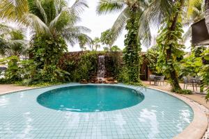 a swimming pool with a waterfall and palm trees at Amazon Plaza Hotel in Cuiabá