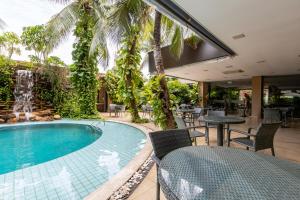 a swimming pool with chairs and a fountain at Amazon Plaza Hotel in Cuiabá