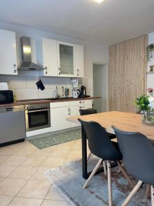 a kitchen with a wooden table and chairs in it at Blick auf die Kirche in Ubstadt-Weiher