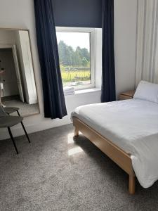 un dormitorio con una cama y una ventana en Springbank Apartment, en Aberdeen