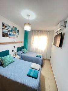 APARTAMENTO SITUADO EN EL CENTRO CON 3 HABITACIONES, DISPONE DE AIRE ACONDICIONADO Y WIFI A 150m DE LA PLAYA Y EL CASTILLO的电视和/或娱乐中心