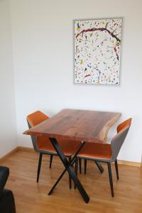 tavolo e sedie in una stanza con un quadro di Ferienwohnung Bella Vista a Eimeldingen