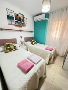 APARTAMENTO SITUADO EN EL CENTRO CON 3 HABITACIONES, DISPONE DE AIRE ACONDICIONADO Y WIFI A 150m DE LA PLAYA Y EL CASTILLO客房内的一张或多张床位