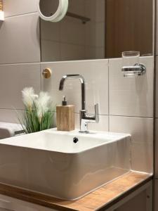 a white sink in a bathroom with a mirror at Apartment Helena in Bad Goisern +40 photos
