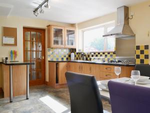 a kitchen with a table and chairs and a kitchen with a window at Briar Rigg in Keswick