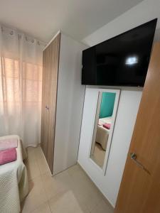APARTAMENTO SITUADO EN EL CENTRO CON 3 HABITACIONES, DISPONE DE AIRE ACONDICIONADO Y WIFI A 150m DE LA PLAYA Y EL CASTILLO的电视和/或娱乐中心