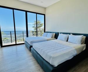 two beds in a room with a view of the ocean at Coco Rica Luxury Oceanview Villa in Carrillo +41 photos