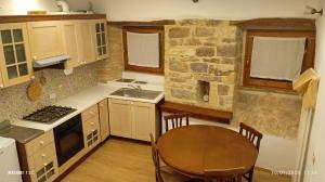 a kitchen with a wooden table and a table and a dining room at Residenza Nora in Bevagna