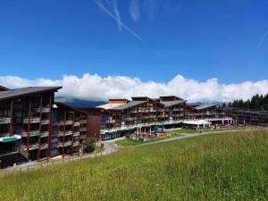 szereg budynków apartamentowych z zielonym polem w obiekcie Résidence Tournavelles - Appartement 2 pièces 5 personnes avec vue sur les pistes, skis aux pieds et des commerces, proche de l'ESF et de la garderie dan MAE-2071 w mieście Arc 1800