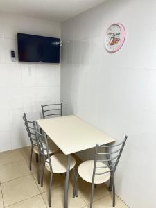 佩尼斯科拉APARTAMENTO SITUADO EN EL CENTRO CON 3 HABITACIONES, DISPONE DE AIRE ACONDICIONADO Y WIFI A 150m DE LA PLAYA Y EL CASTILLO的桌子、椅子和墙上的时钟