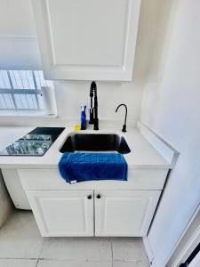 a kitchen sink with a blue towel next to it at Modern Home - Termpurpedic Queen bed, Laundry, Free Parkging, EV Tesla in Hollywood