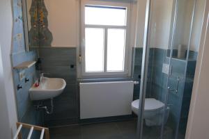 a bathroom with a sink and a toilet and a window at Naturgarten Karlsfeld in der schönen Lausitz in Welzow +28 photos
