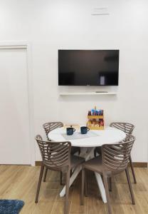 a dining room with a white table and chairs at Maria Grazia's House in Ercolano +3 photos