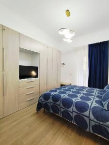 a bedroom with a bed and a flat screen tv at Maria Grazia's House in Ercolano