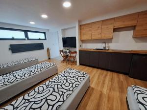 two beds in a room with a kitchen and a kitchen at Apartamet typu studio ELEPHANT dla 4 osób in Płock