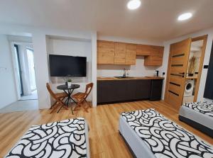 a living room with two beds and a kitchen at Apartamet typu studio ELEPHANT dla 4 osób in Płock +7 photos