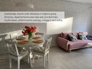 a living room with a table and a couch at Palūšės Apartment in Palūšė