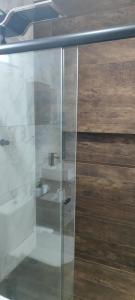 a glass door of a bathroom with a sink at Chalé Vista da Serra in Cunha +19 photos