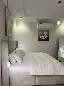 a bedroom with a large white bed and a television at Rfaa Suites in Medina