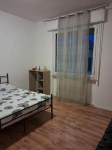 a white bedroom with a bed and a window at Camera "Il Giarasole" in Pistoia