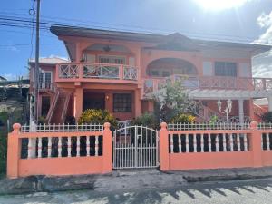 a pink house with a white fence in front of it at Boyce Guest House in Black Rock