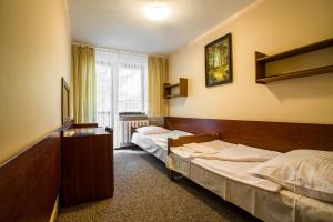 a hotel room with two beds and a window at OW Inter Piast własna plaża z kąpieliskiem i przystań in Dąbrówno