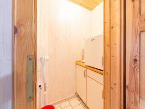 a small kitchen with a refrigerator and a counter at Ferienhaus mit einladendem Platzangebot in Granzow +19 photos