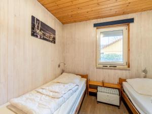 two beds in a small room with a window at Ferienhaus mit einladendem Platzangebot in Granzow