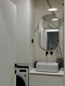 a bathroom with a white sink and a mirror at Miol apartment in Kaštela +10 photos