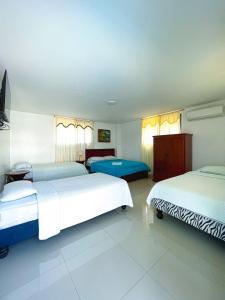 a hotel room with two beds and a room with at HOSTAL PIAZZOLLA in Manta
