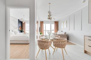a kitchen and living room with a table and chairs at Rent Invest - Quorum Apartamenty Parking Klimatyzacja in Wrocław