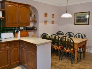 a kitchen with a table and chairs and a counter at Daisy Bank Cottage in Bowness-on-Windermere