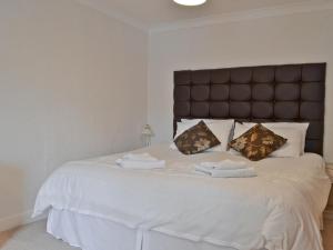 a bedroom with a large white bed with towels on it at Daisy Bank Cottage in Bowness-on-Windermere +3 photos