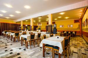 un ristorante con tavoli, sedie e pareti gialle di OW Inter Piast Kalbornia - z własną plażą z kąpieliskiem i przystanią a Dąbrówno