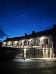 a building with lights on the side of it at night at La ferme aux chats in Formigny