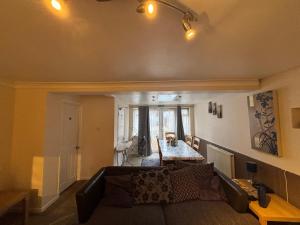 a living room with a couch and a table at Shared Home - Self Check-In - Resident Cat in Hatfield +3 photos