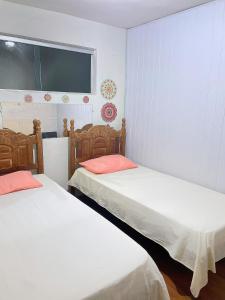a room with two beds and a window at Hostel Diamante in Diamantina