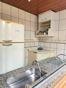 a kitchen with a sink and a refrigerator at Hostel Diamante in Diamantina