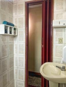 a bathroom with a white sink and a red door at Hostel Diamante in Diamantina +25 photos