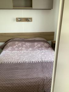 a bed in a small room with a purple comforter at Montourey 83 ES 119 in Fréjus +12 photos