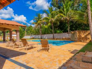 a patio with chairs and a swimming pool at Casa de Campo I Cond Ninho Verde II in Pardinho