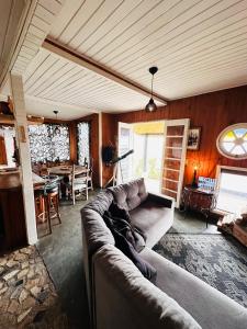 ein Wohnzimmer mit Sofa und Tisch in der Unterkunft Chalé acima das nuvens - Serra da Bocaina in São José do Barreiro