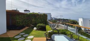 eine Terrasse mit Stühlen und einen Garten auf dem Balkon in der Unterkunft Olympic Park C 606 Apartament z ogrodem na dachu in Kołobrzeg