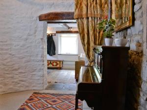 a hallway with a piano and a window in a room at East House Farm in Beckermonds +10 photos